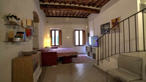 Ein Schlafzimmer mit einem Bett, einem Schminktisch, einem Fernseher und einer Treppe.