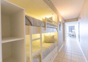 Ein Schlafzimmer mit Etagenbetten und einem Flur, der zu einem Badezimmer führt.
