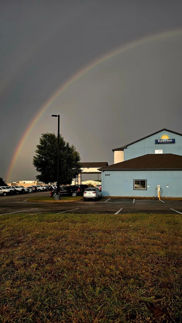 A Days Inn building with a parking lot and a visible rainbow.
