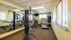 A gym with exercise equipment, a treadmill, and a mirror.