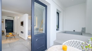 A modern bathroom with a bathtub and a shower area. - George & Joanna Suites (Santorini)