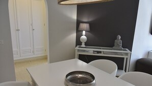 Ein modernes Zimmer mit einem weißen Tisch, einer Lampe und einer Statue.