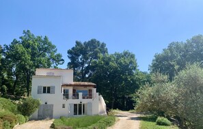 A two-story house with a balcony, surrounded by greenery and trees. - Aix-en-Provence, provencal family house (Éguilles)