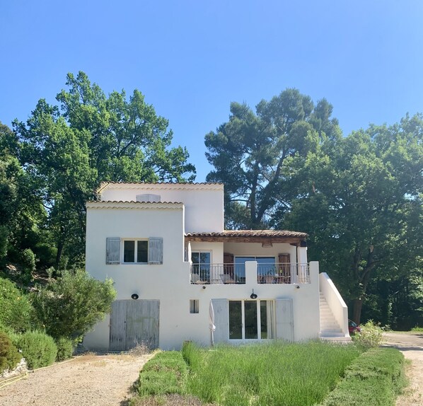 A two-story house with a balcony, surrounded by greenery and trees. - Aix-en-Provence, provencal family house (Éguilles)