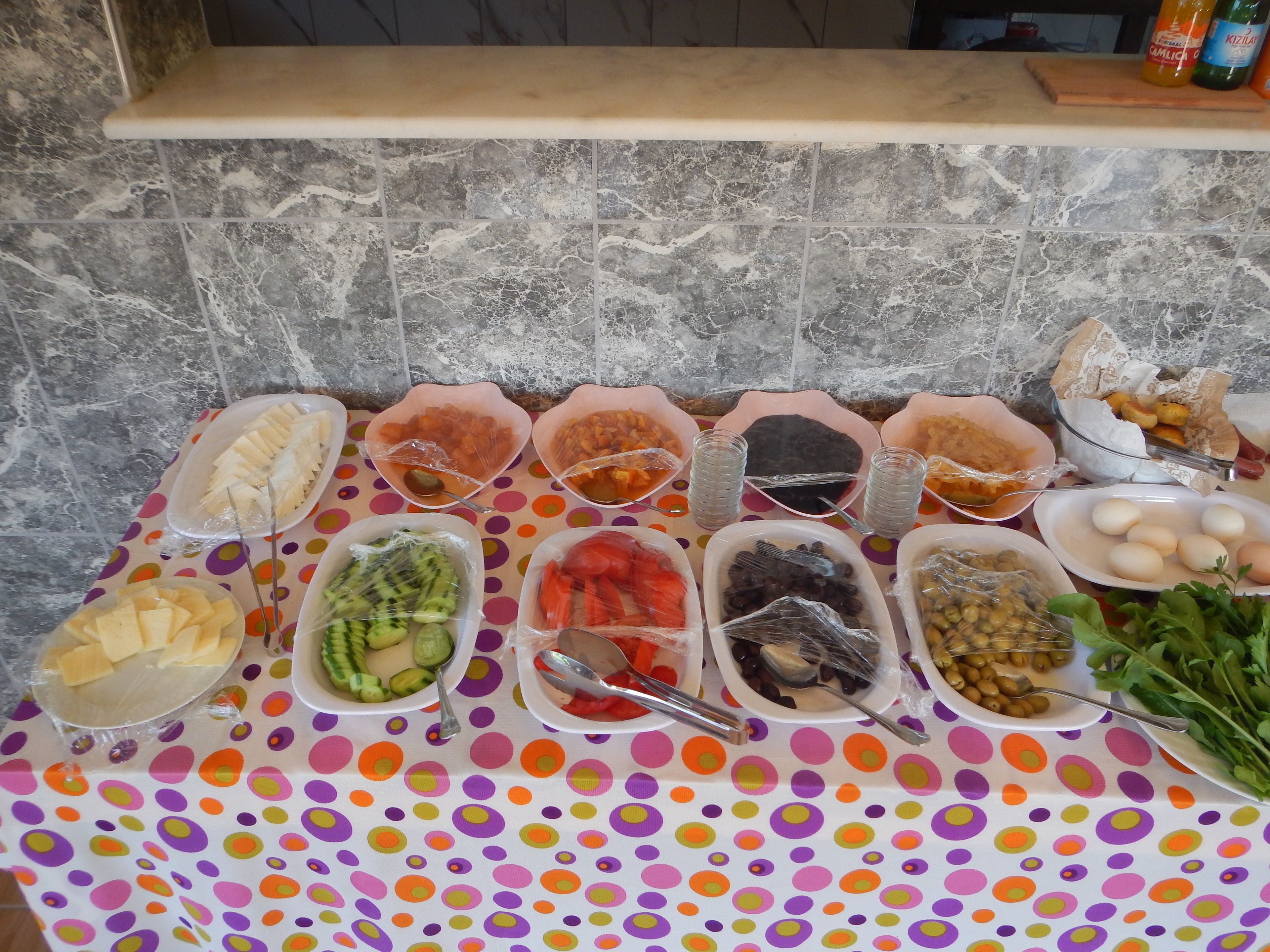A buffet table with various food items and condiments.