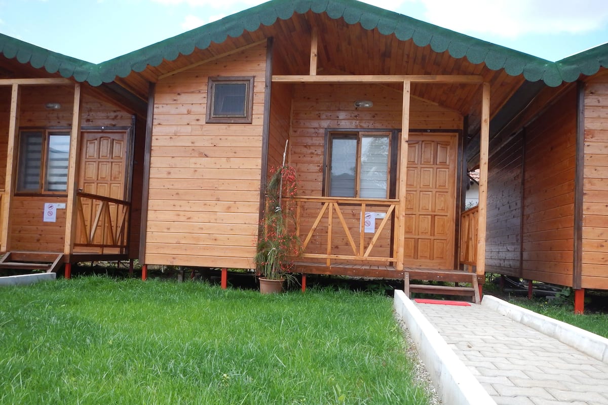 Una cabana de fusta amb un porxo, una finestra petita i una porta.