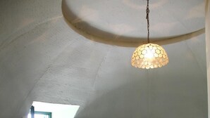 A bedroom with a bed, a table, a hanging light fixture, and a window. - Astrocamp (Verghereto)
