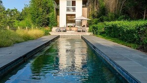 Une maison moderne à deux étages avec une piscine à l’avant.