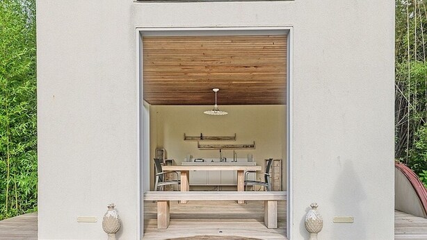 Un espace spa doté d’une terrasse en bois, d’un bain à remous et d’un coin salon avec une table et des chaises.