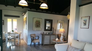 A spacious living area with a dining table, a sofa, and a coffee table. There are chairs, a cabinet, and a lamp. - Corfu Golf Countryhouse (Corfu)