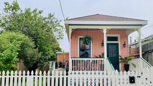 A small house with a porch, a white picket fence, and a green door. - Stylish 2 BED, 2 BATH Shotgun-style house near beach! (Galveston)