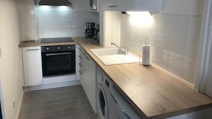Una cocina compacta con horno, microondas y lavadora integrados.