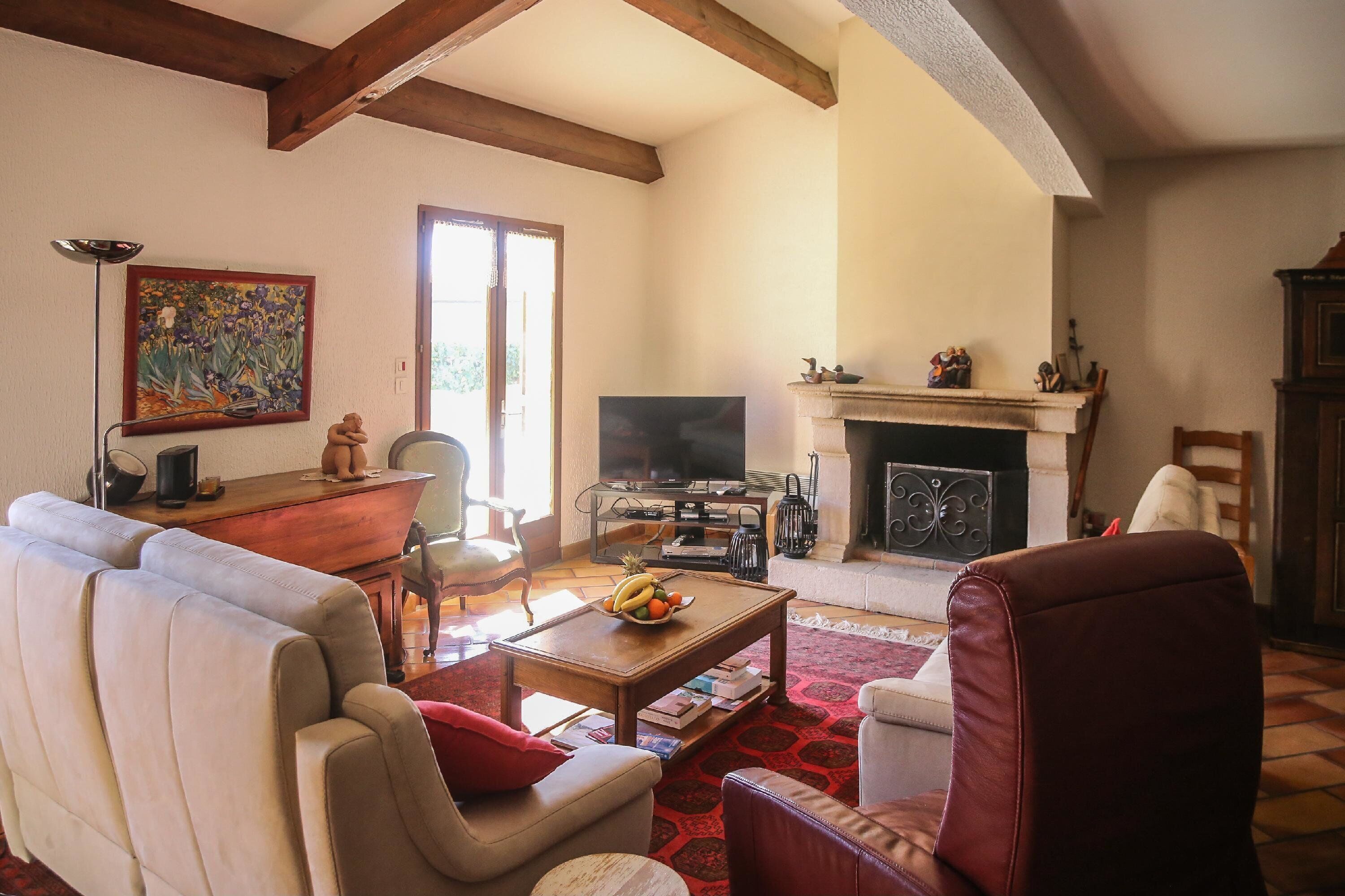 Télévision, cheminée, lecteur de DVD, livres