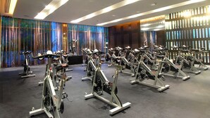 A gym with stationary bikes arranged in rows, a large mirror, and a modern ceiling design. - Vidanta, 5 Diamond Resort 1Br 1 1/2 Ba + golf 2 for 1 massages (Nuevo Vallarta)