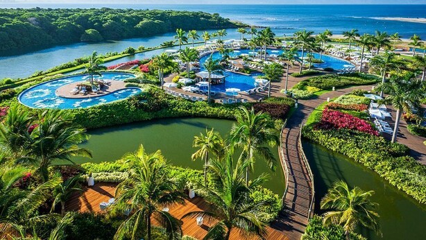 A resort with multiple swimming pools, lush greenery, and a view of the ocean. - Vidanta, 5 Diamond Resort 1Br 1 1/2 Ba + golf 2 for 1 massages (Nuevo Vallarta)
