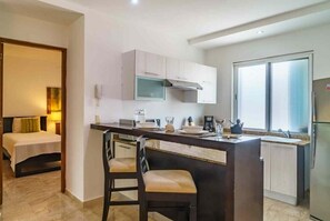 Enjoy a compact kitchenette with a stove, microwave, and sink, plus a dining area with a table and chairs.