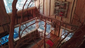 Un intérieur en bois avec un balcon, une fenêtre et un écran fixé au mur.