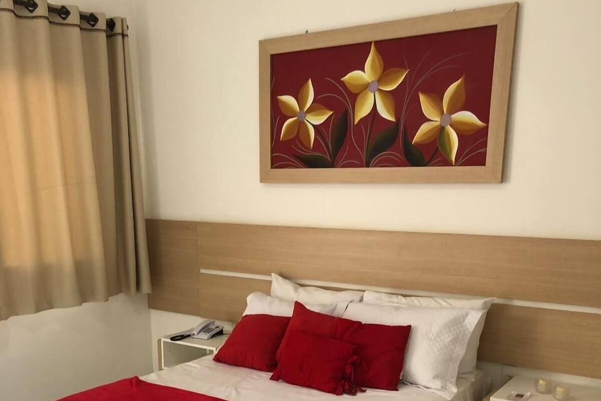 Ein Hotelzimmer mit einem großen Bett, einem Nachttisch und einem Wandbild.