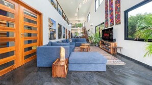 A spacious living area with a large sectional sofa, wooden sideboard, and a TV.