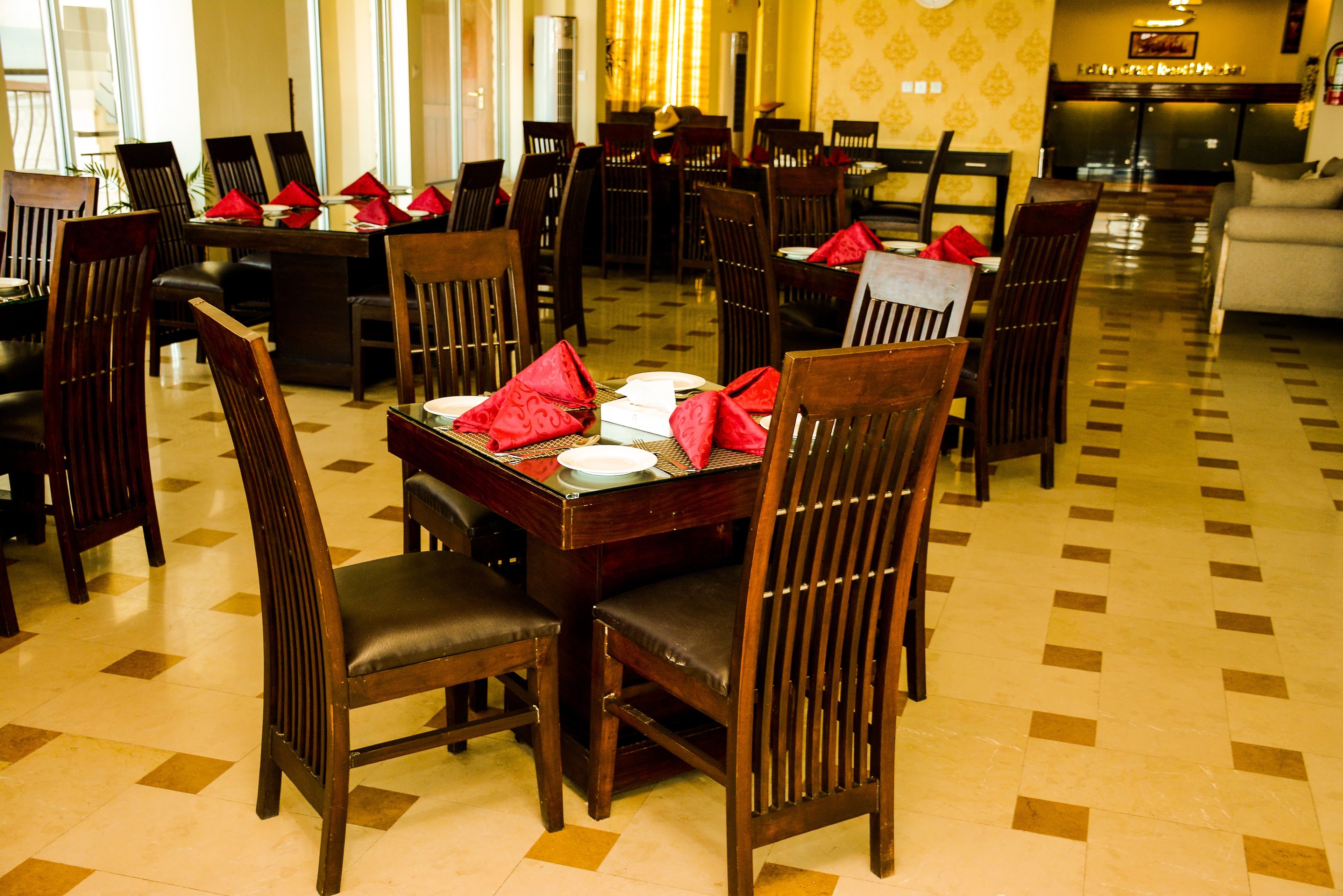 A dining area with multiple tables and chairs, arranged in a spacious layout.