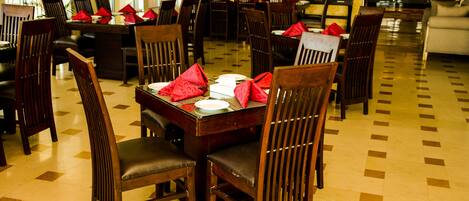 A dining area with multiple tables and chairs, arranged in a spacious layout.