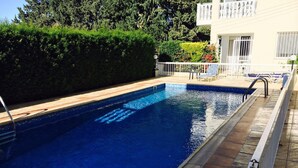 A rectangular swimming pool with a tiled edge, surrounded by a tiled deck. - Apartment in Kato Paphos (Phafos)