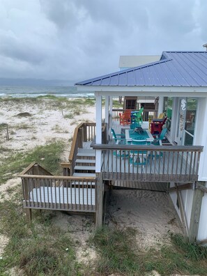 A beach house with a deck, outdoor seating, and a view of the ocean. - Amazing Beach  Views & Access (Gulf Shores)