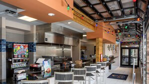A restaurant with a bar area, seating, and a kitchen in the background. - 5Star Resort/Clean and Safe/Mins to Parks/WaterPark/Arcade/Bar/Gym/Golf/AC/WiFi (Davenport)