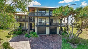 A two-story house with a balcony, a garage, and a brick driveway. - 41 Carlo Circle - Rainbow Beach. Huge Beach House With Room for Everyone! (Rainbow Beach)