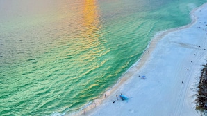 Une plage aux eaux turquoise et limpides, avec un coucher de soleil.