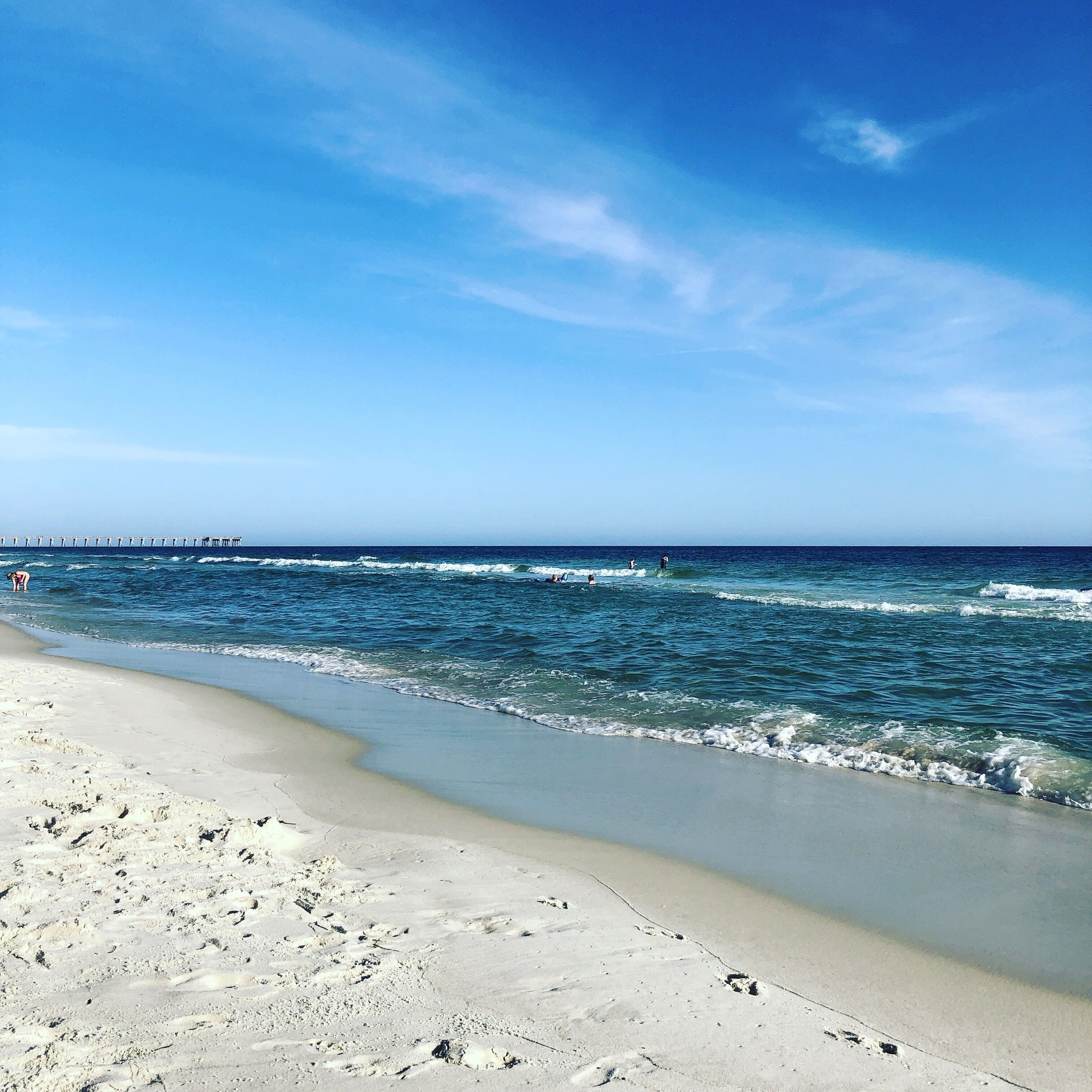 A beach with clear skies and calm waves.