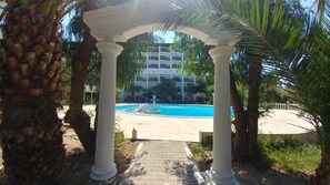 Een binnenzwembad, een buitenzwembad en parasols bij het zwembad