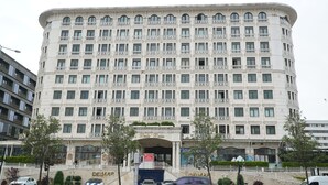 Un hotel a più piani con un design architettonico classico, caratterizzato da balconi e un ingresso centrale.