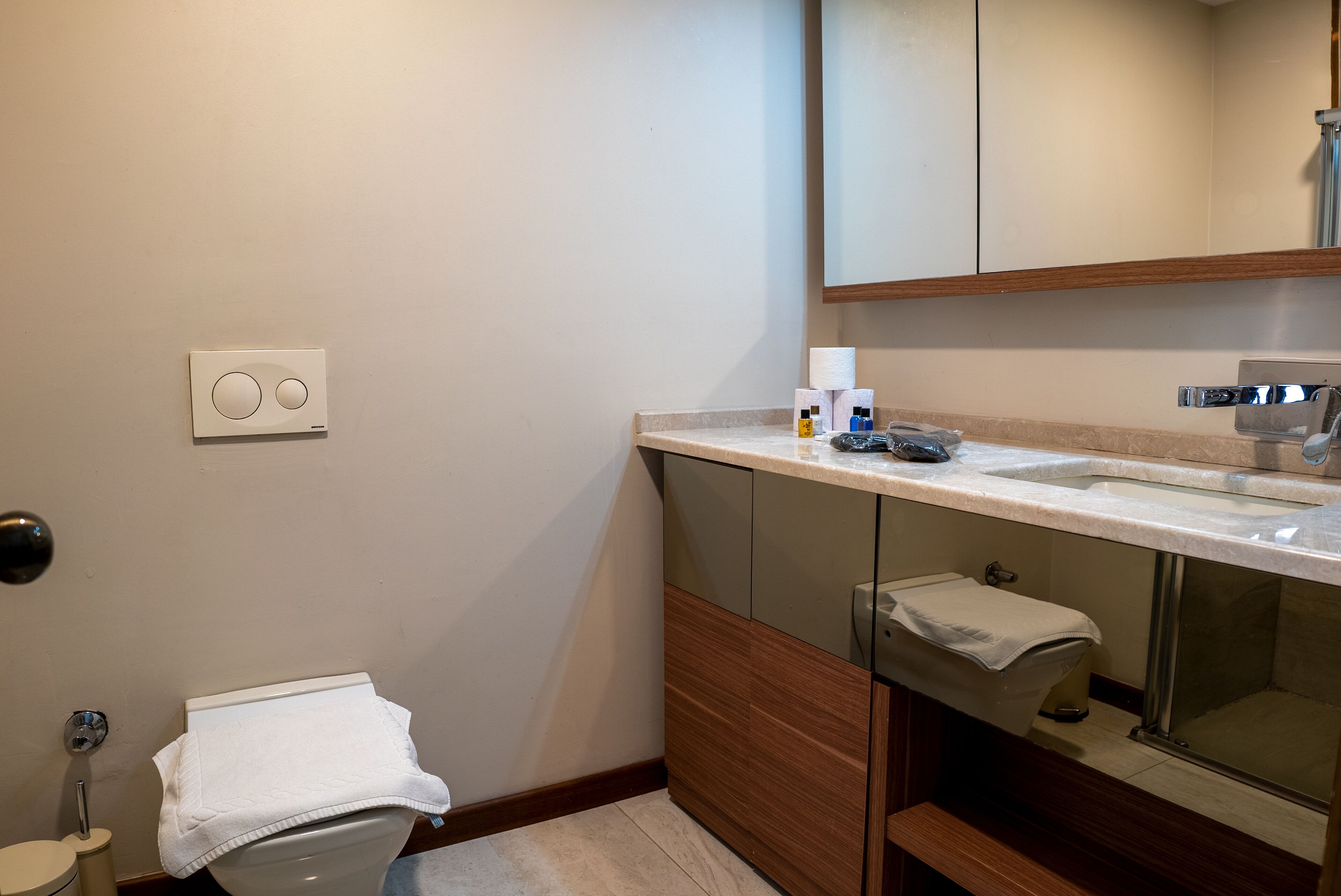 Un baño moderno con inodoro, lavabo y espejo.