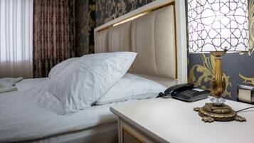 A hotel room with a bed, a bedside telephone, and a lamp.