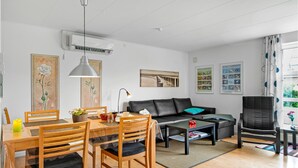 Un salon moderne avec un coin repas, comprenant un canapé, une table basse et une table à manger avec des chaises.