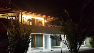 Vista frontal de la propiedad por la tarde o noche