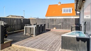 A rooftop patio with a hot tub, outdoor seating, and a wooden deck. - Cozy home in Thyborøn with sauna (Thyborøn)