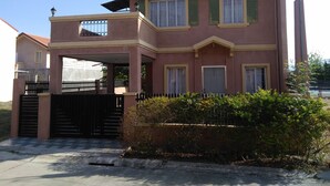 A two-story house with a balcony, a gated entrance, and a well-maintained garden. - San Fernando Pampanga (Sanfernando)