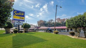 A Scottish Inns sign, a welcoming sign, and a motel with a red roof. - Knights Inn Collinsville Va (Collinsville)