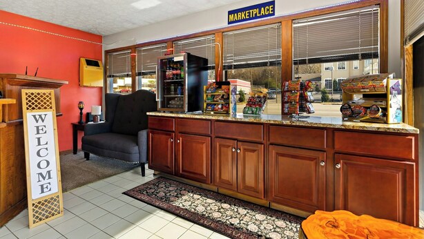 A kitchenette with a 'WELCOME' sign, a refrigerator, and a window with blinds. - Knights Inn Collinsville Va (Collinsville)
