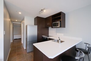 Departamento urbano, vista al océano | Cocina privada | Horno, parrilla de estufa, lavavajillas y utensilios de cocina 