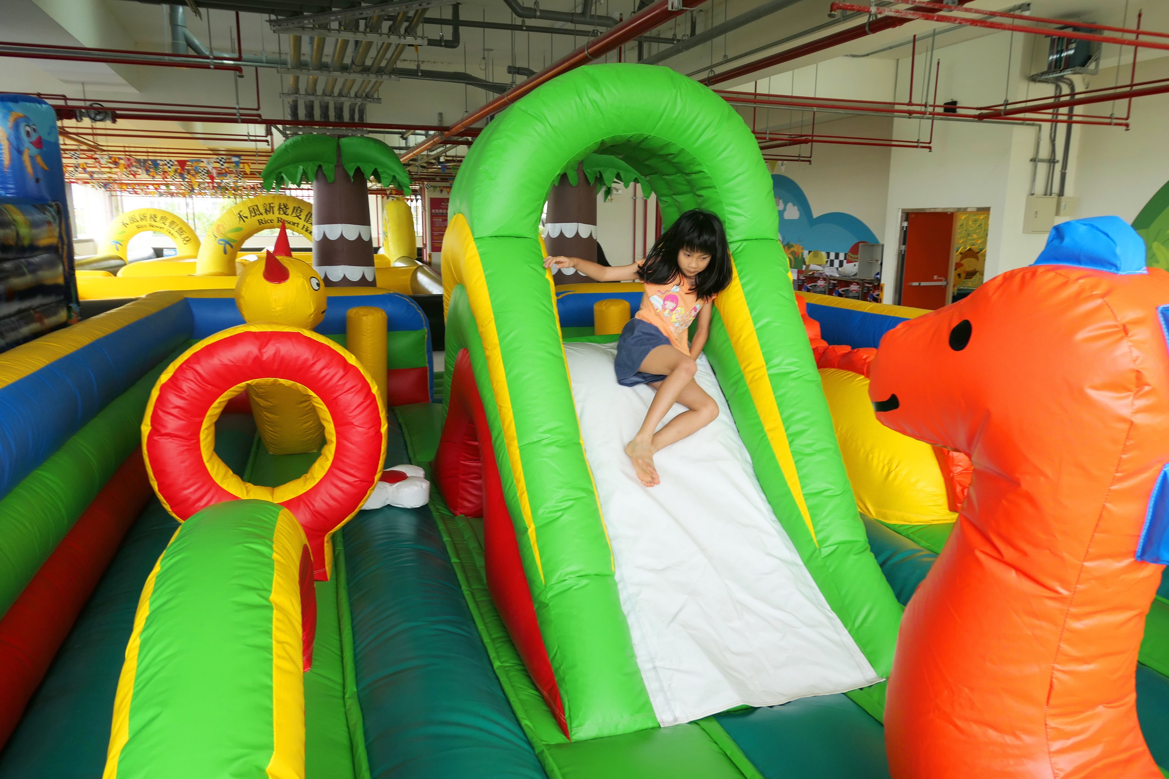 Un área de juegos inflable en el interior con toboganes y túneles.