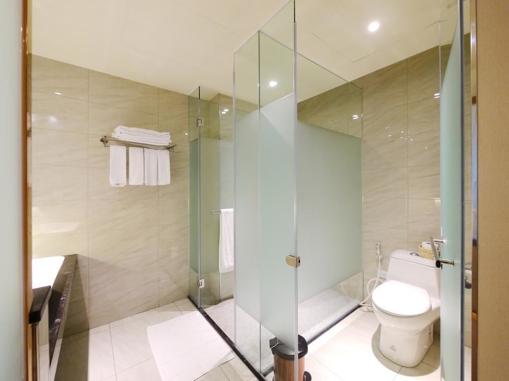 A modern bathroom with a glass partition, a toilet, and a sink.