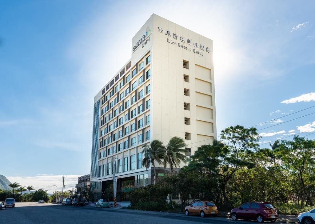 Un hotel de varios pisos con un diseño moderno, que destaca un letrero grande en la parte superior.