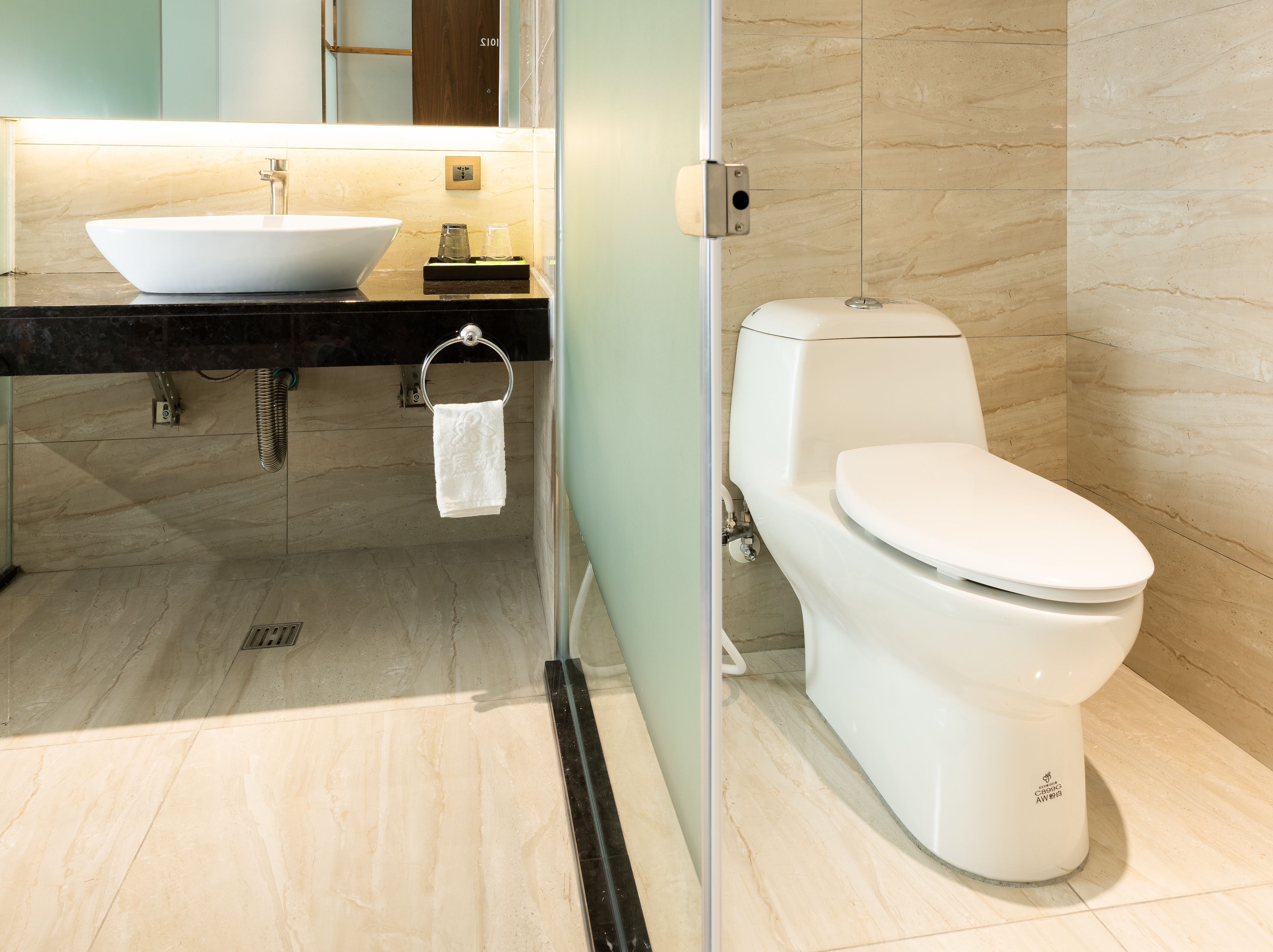 A modern bathroom with a white sink, toilet, and a towel rack.