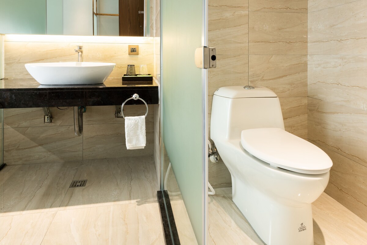 A modern bathroom with a white sink, toilet, and a towel rack.