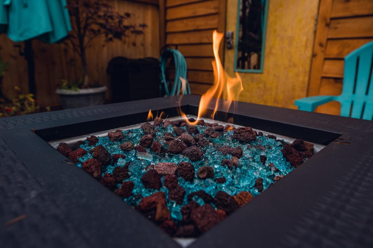 Ein Lagerfeuer mit brennendem Holz und Glassteinen.