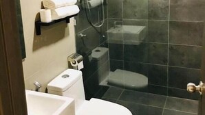 Une salle de bain avec des toilettes, une douche et un lavabo.