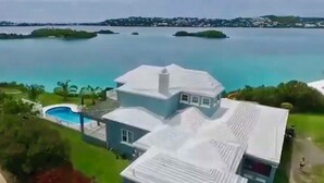 A large house with a swimming pool, surrounded by greenery and a view of the sea. -  Romantic - Pool & Ocean View, WiFi, Kayaks, parking  (Hamilton)